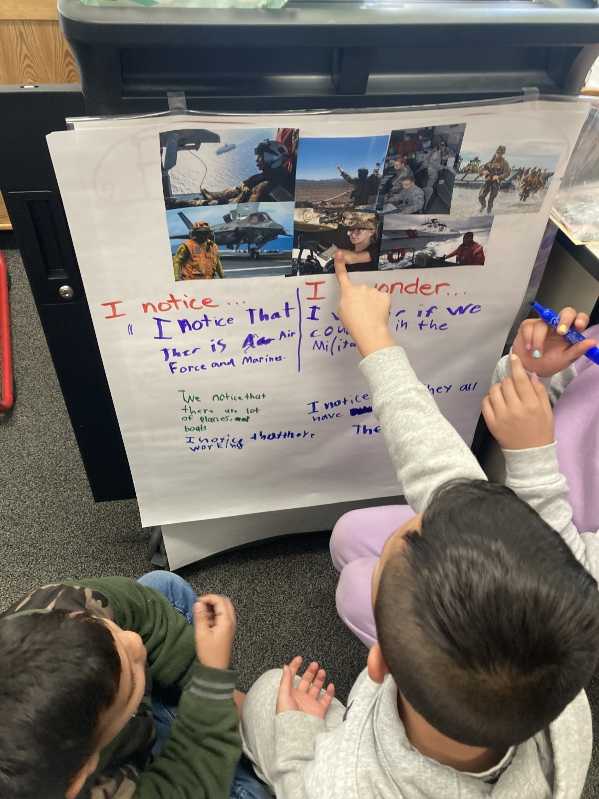 Students pointing to posterboard